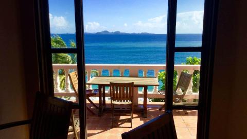 Scenic balcony view overlooking sea with mountains, ideal for relaxing.