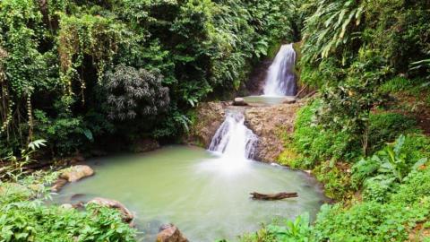 Scenic tropical waterfall with turquoise pool and lush greenery, ideal for nature enthusiasts
