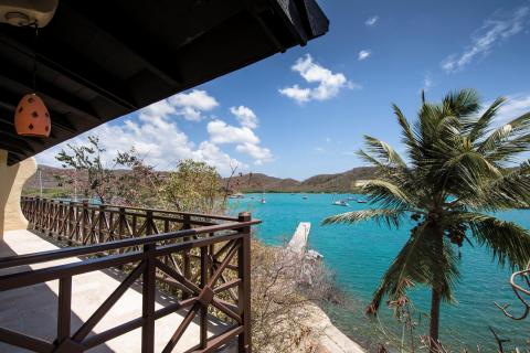 Scenic coastal view from balcony with birdhouse overlooking turquoise bay and boats