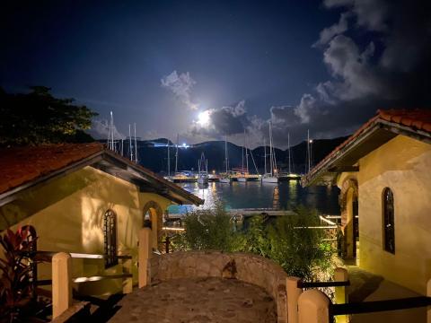 Full moon over sailboats in bay, Mediterranean coastal town at night