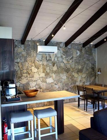 Cozy café interior with stone wall, wooden beams, and stylish counter.