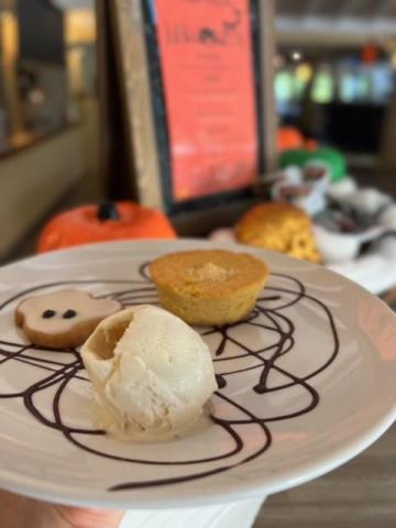 Halloween dessert plate with vanilla ice cream, pumpkin cake, and ghost cookie
