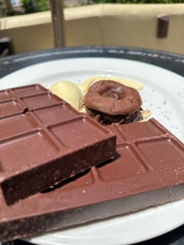 Chocolate plate with cake on outdoor cafe table, ideal for brunch dessert.