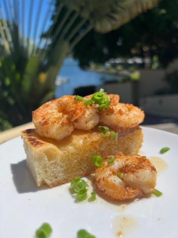 Grilled shrimp on toast with green onions, served outdoors.