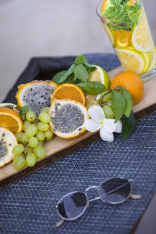 Refreshing citrus beverage with tropical fruits, sunglasses on side
