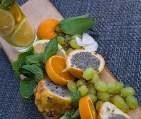 Fresh fruits and citrus-infused beverage on a wooden board