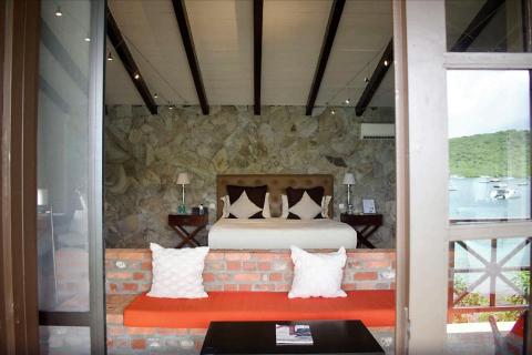 Luxurious room with rustic decor and scenic bay view through large window.