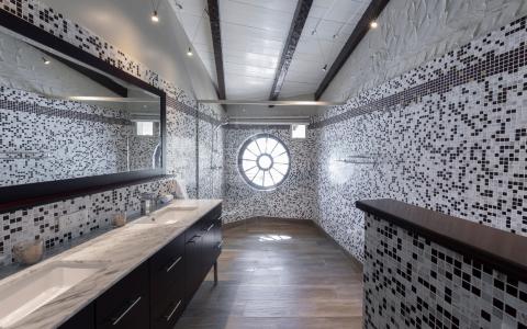 Modern bathroom with marble sinks, mosaic tiles, and chic lighting.
