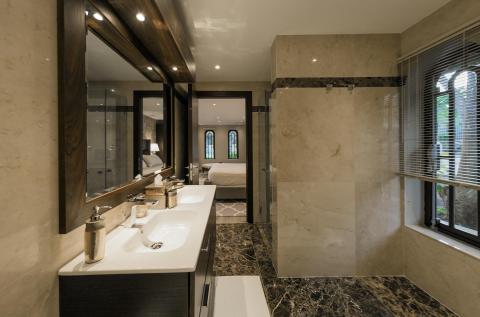Luxurious bathroom with marble tiles, dual sinks, and large mirror
