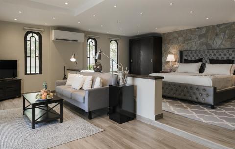 Modern bedroom with tufted headboard, stone wall, and serene decor