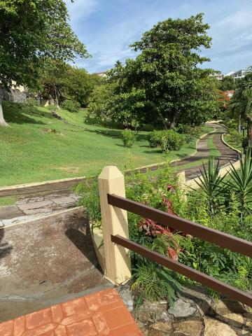 Lush green park with curving path, stairs, and sunny weather
