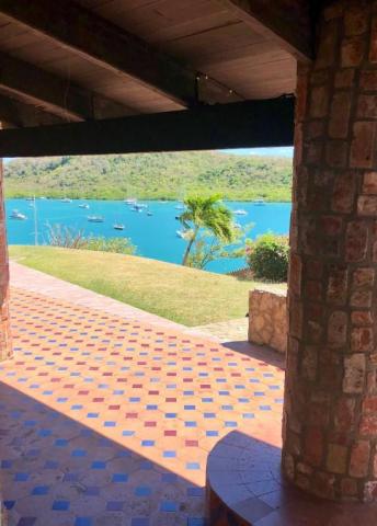 Scenic view from covered patio with terra cotta tiles overlooking boats on water