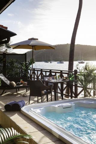 Luxurious patio with hot tub overlooking bay with sailboats, tropical setting