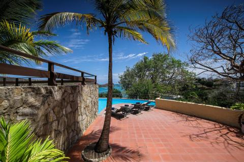 Luxurious tropical terrace with private pool, sun loungers, and sea view.