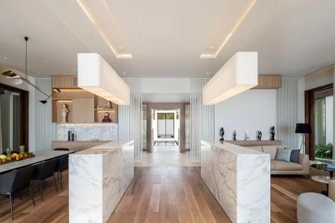 Modern house interior with marble kitchen island and stylish dining area.