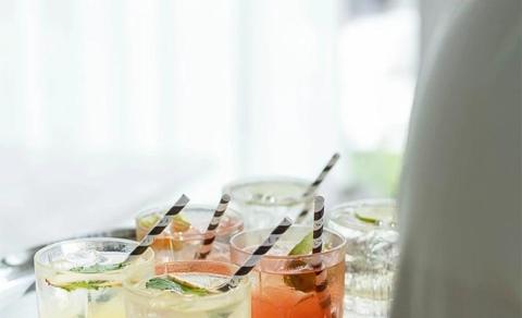 Assorted refreshing drinks with mint garnish in clear glasses, colorful straws