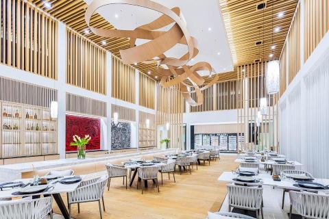 Luxury dining area with wooden ribbon sculpture and stylish seating.