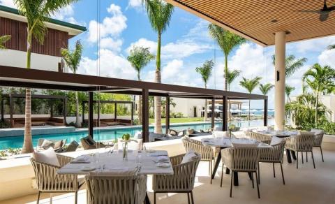 Upscale outdoor dining area with pool and sea view, modern decor