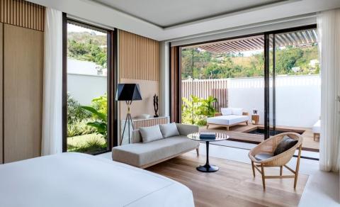 Stylish bedroom with seamless transition to a serene outdoor patio area.