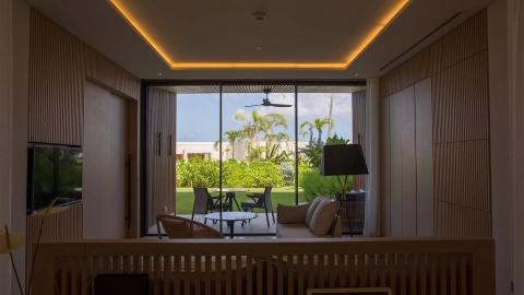 Elegant modern home interior with garden view through sliding glass doors.