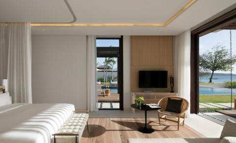 Modern living room with pool view, wooden floors, and minimalist decor.