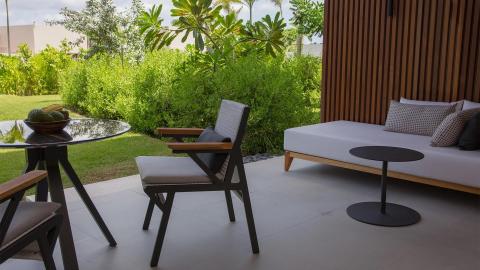 Stylish outdoor patio with lush greenery and modern furniture.