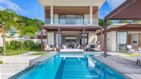 Luxury villa with outdoor pool, modern design, and lush tropical landscaping