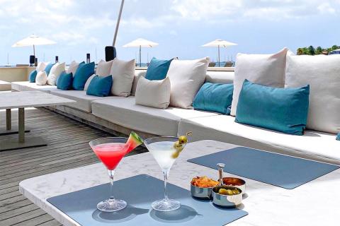 Luxurious ocean-view lounge with cocktails and snacks on wooden deck