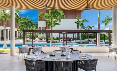 Elegant outdoor dining at a tropical resort with pool and palm trees