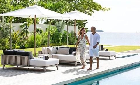 Luxurious outdoor poolside scene with couple walking and chatting by the sea.