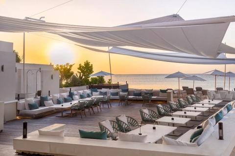 Luxurious seaside lounge area with sofas and sunset view for relaxation.