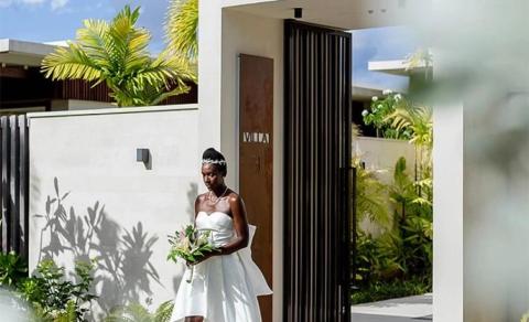 Bride in white dress holding bouquet at Villa 3, tropical setting