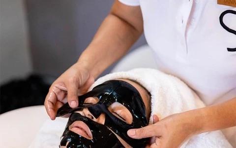 Therapist applying face mask in spa setting for skincare treatment