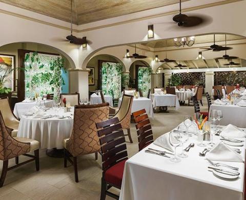 Elegant restaurant interior with archways, fine dining setup, and soft lighting
