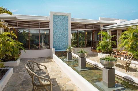 Modern outdoor resort design with blue mosaic fountain and lush greenery