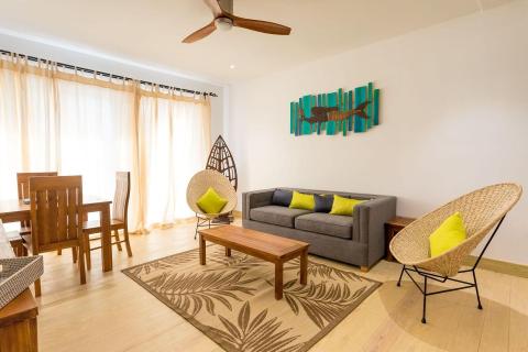 Modern living room with gray sofa, wooden dining set, and blue deer artwork.
