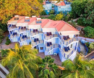 Aerial view of a tropical residential complex with blue and white buildings