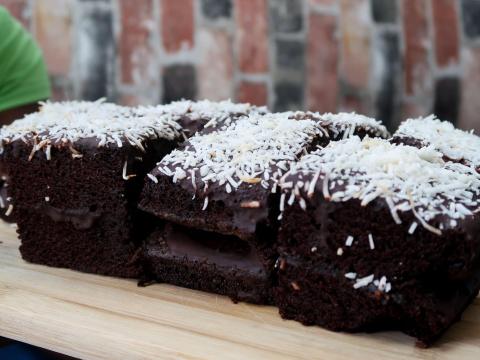 Chocolate cake slices with coconut topping on a wooden board