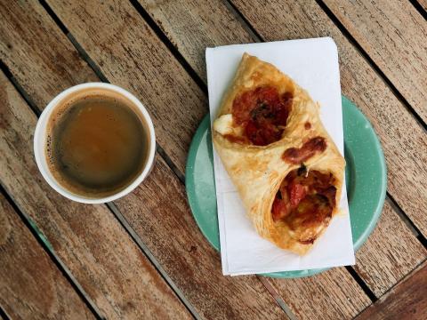 Coffee and pastry with tomatoes on rustic wooden table