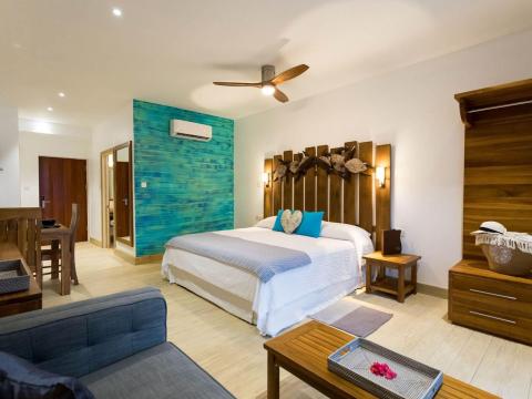 Modern spacious bedroom with blue accent wall, large bed, and seating area