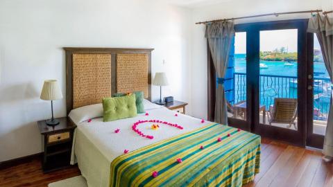 Romantic bedroom with heart-shaped petals on bed overlooking harbor