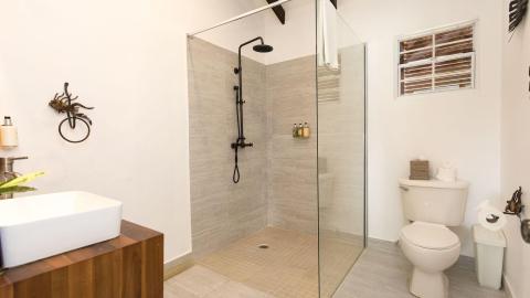 Modern bathroom with walk-in shower, wooden vanity, and unique metallic decor.