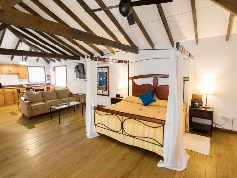 Cozy studio apartment with modern decor, wooden beams, and rustic charm.
