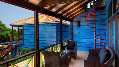 Tropical resort with blue cabin and lush greenery, ideal for relaxation.