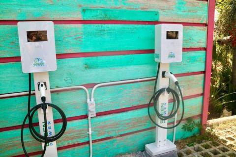 EV charging stations against a turquoise wooden wall, eco-friendly design.