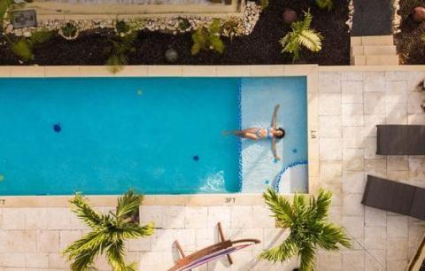 Aerial view of a person floating in a serene rectangular swimming pool