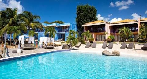 Luxurious tropical resort pool with sun loungers, cabanas, and palm trees