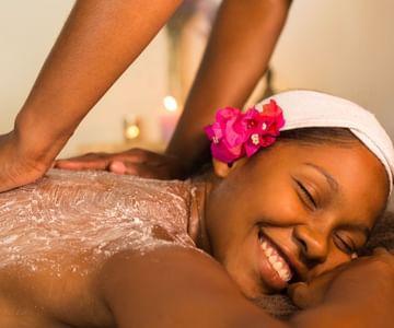 Young woman enjoying a relaxing spa massage with pink flower
