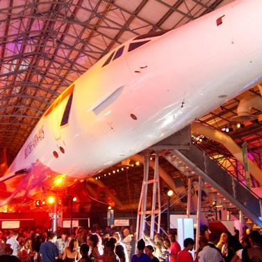 Barbados Social Event Interior with Airplane and Crowd An event with people gathered under an airplane inside a hangar