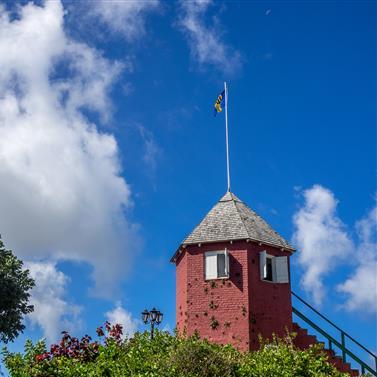 Barbados Historical Structure under Blue Sky Barbados historical red tower with a flag